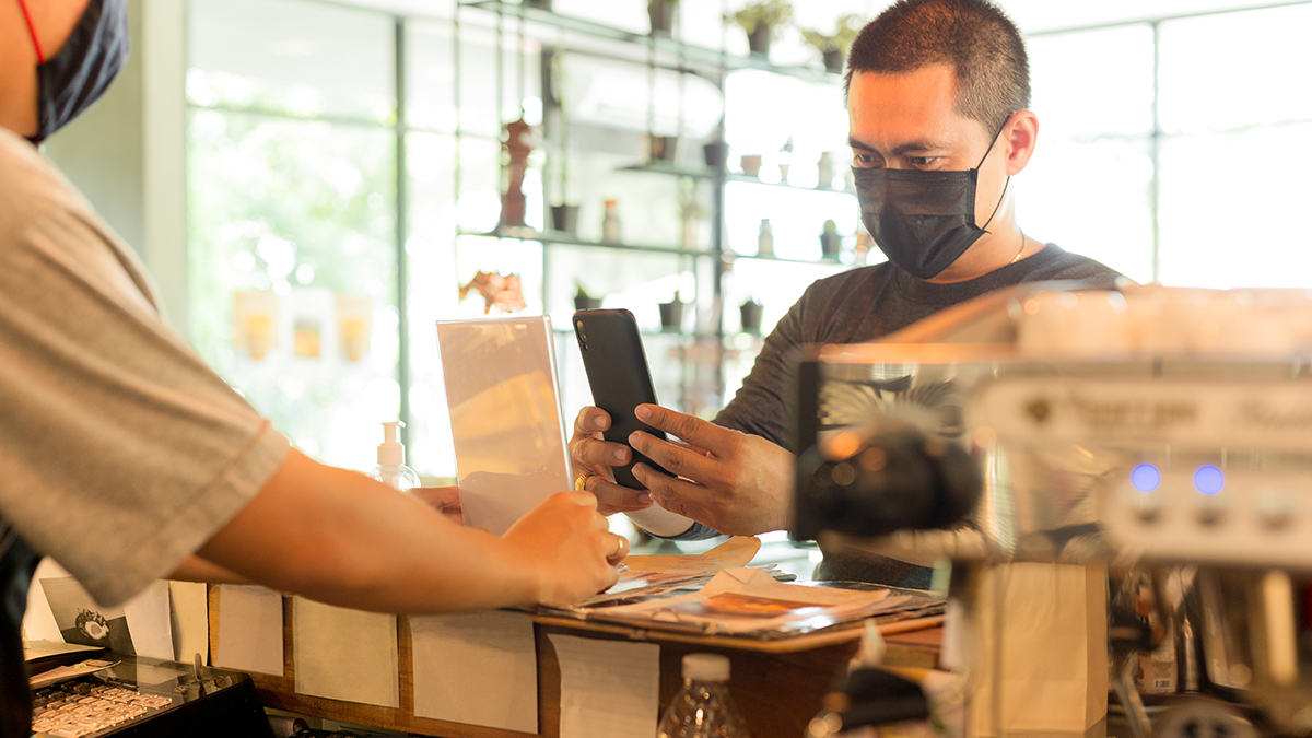 Man buying something at a shop using a phone