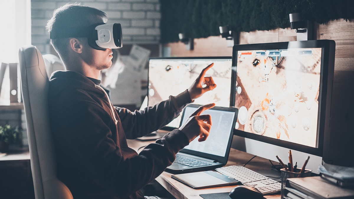 A young man with a virtual reality headset in a creative office.
